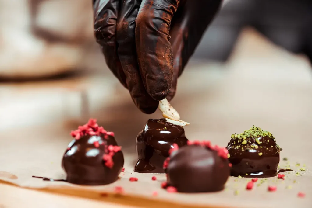 chocolatier in black latex gloves